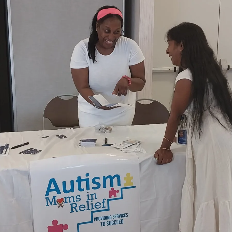 Dr. Caldwell Page sharing resources at an Autism Moms in Relief community table